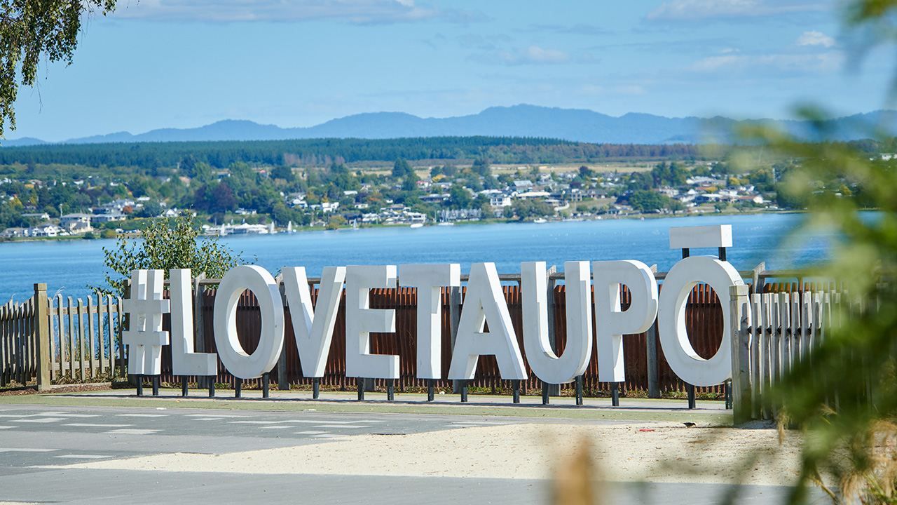 Love Taupo sign with lake behind