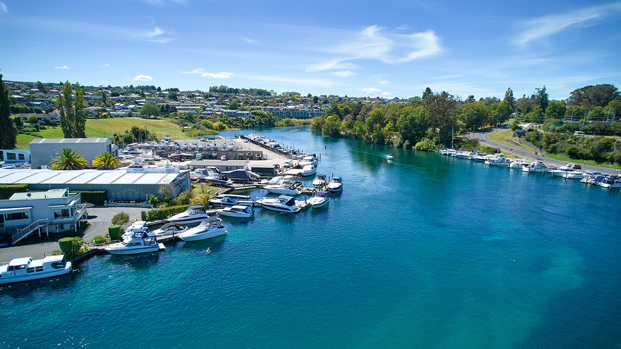 Image of marina showing many boats and blue water